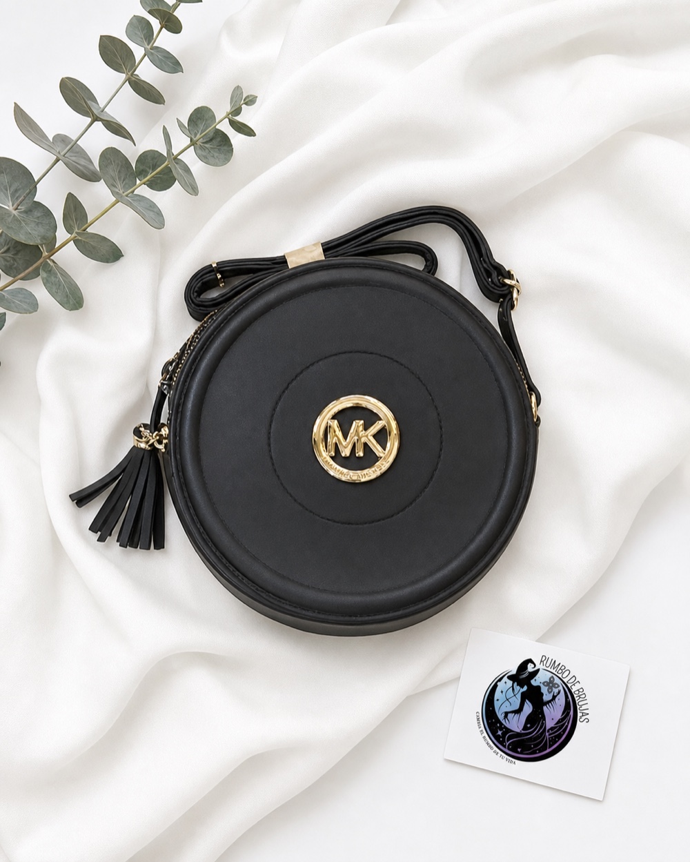 Bolso redondo negro con emblema dorado — Rumbo de Brujas