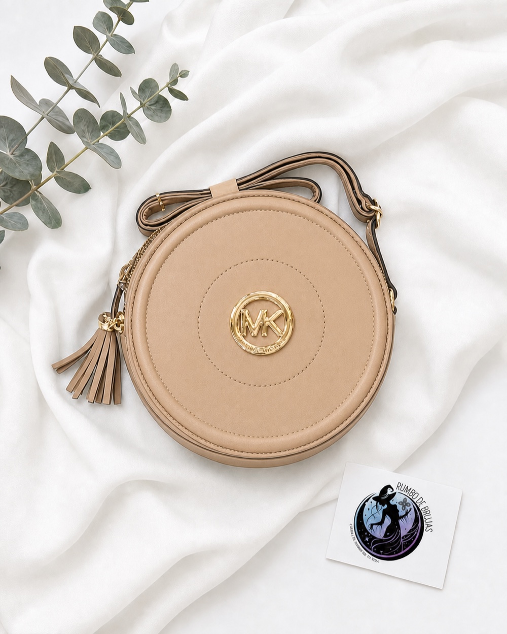 Bolso redondo beige con emblema dorado — Rumbo de Brujas